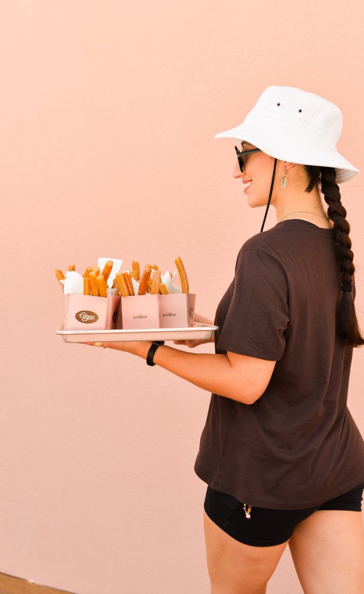 Server with a tray of churros